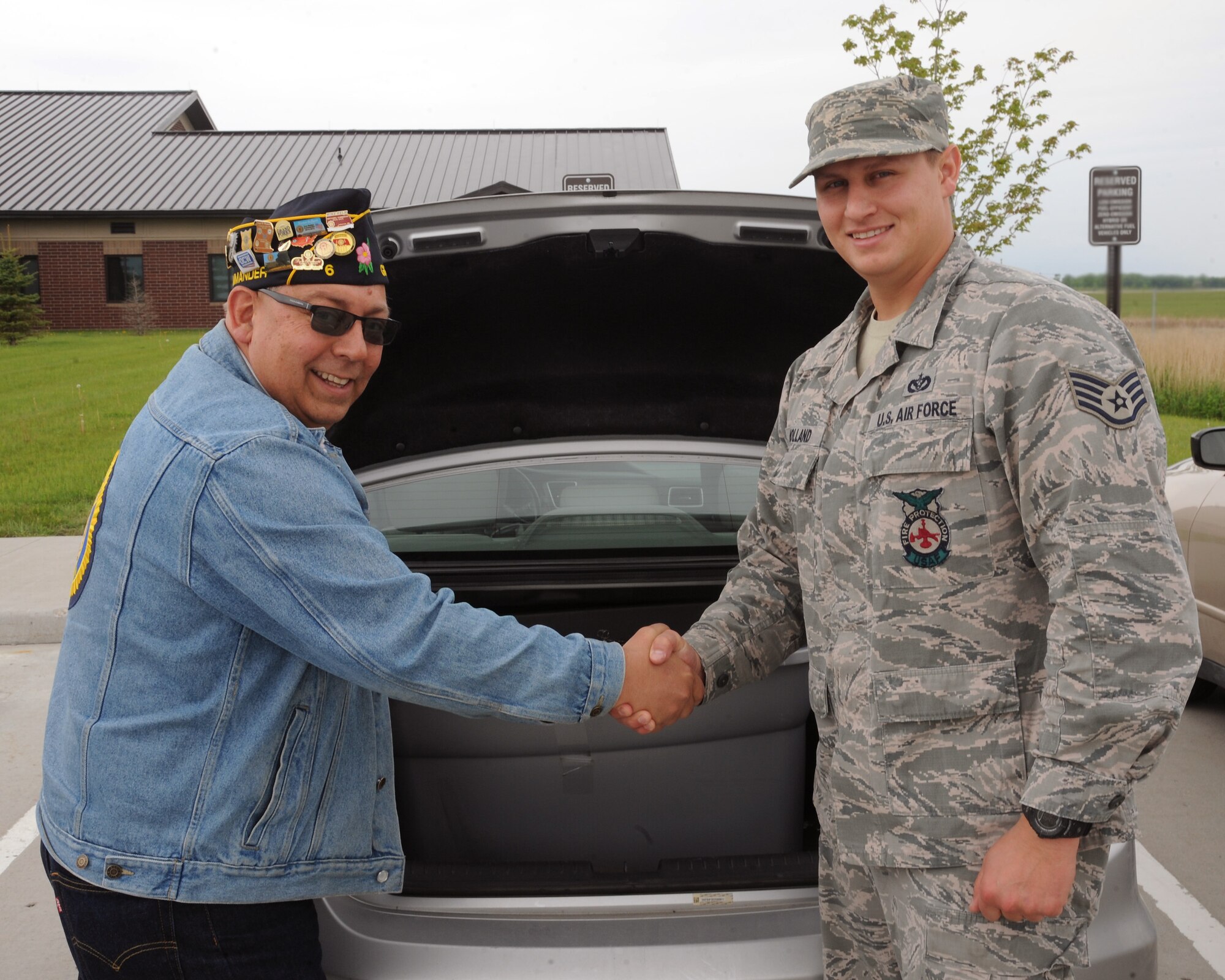 Bob Greene, American Legion Post 6 commander, and Staff Sgt. Shane Holland, 319th Civil Engineer Squadron fire fighter, stand with a plastic tub full of soda can pull tabs collected by the 319th CES Fire Department throughout the year, June 2, 2015, on Grand Forks Air Force Base, N.D. As a combined effort, the two worked together with each of their organizations to collect soda can pull tabs for the Ronald McDonald House in Bismarck, N.D. In 2014, a grand total of 68,000 soda can pull tabs were collected. (U.S. Air Force photo by Senior Airman Zachiah Roberson/released)