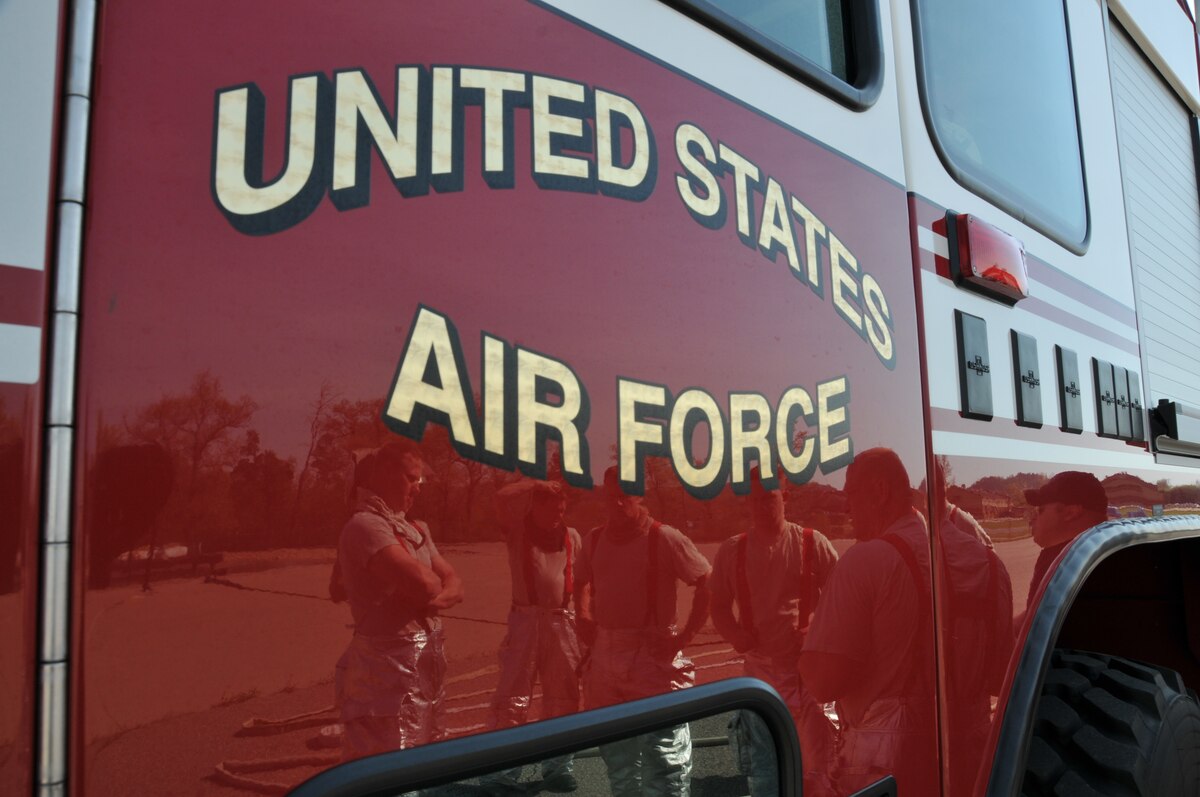 Firefighters from the 114th Civil Engineer Squadron discuss the next exercise during their training at Volk Field, Wisc. May 6, 2015. The firefighters travel to Volk Field each year to hone their basic skills and to train on a simulated burning aircraft. (National Guard photo by Senior Airman Duane Duimstra / released)