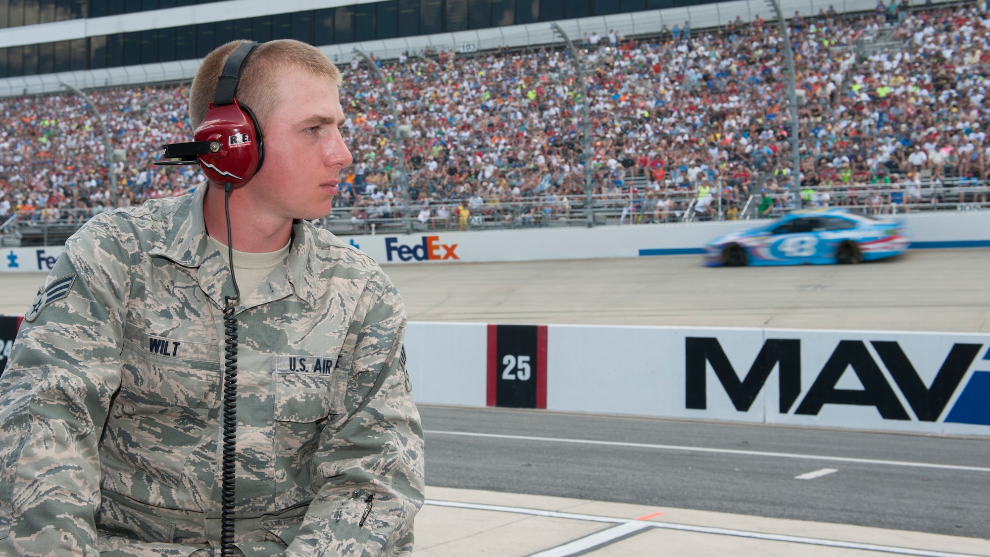 Senior Airman Collin Wilt, 436th Logistic Readiness Squadron material management, watches the FedEx 400 Benefiting Autism Speaks NASCAR race from inside a pit box May 31, 2015, at Dover International Speedway in Dover, Del. Wilt got to experience the race as an honorary pit crew member. (U.S. Air Force photo/Airman 1st Class Zachary Cacicia)