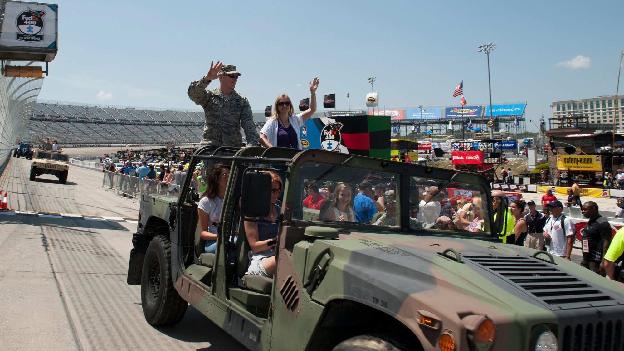 Col. Michael Grismer, 436th Airlift Wing commander, and his wife, Dr. Linda Grismer, wave to fans prior to the start of the FedEx 400 Benefiting Autism Speaks NASCAR race May 31, 2015, at Dover International Speedway in Dover, Del. This parade lap featured the commanders, command chiefs and their respective spouses from the 436th and 512th Airlift Wings. (U.S. Air Force photo/Airman 1st Class Zachary Cacicia)