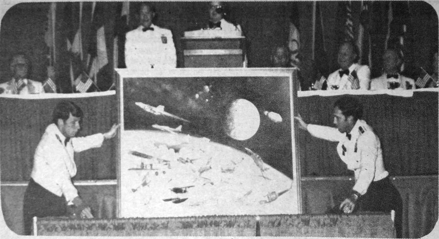 Two Air Command and Staff College students unveil a painting commemorating the “Great Moments in Aviation History” event at the Montgomery Civic Center in Montgomery, Alabama June 4, 1982.  The painting was presented to Brig. Gen. Richard Ingram, 1982 ACSC commandant, by Maj. John Artz, 1982 Air Command and Staff College Class president.  Now known as Gathering of Eagles, the event is held annually by ACSC to honor men and women who have made significant contributions to air, space and cyberspace power.  (1982 Maxwell Dispatch photo)