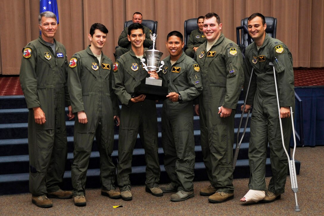 U.S. Air Force Lt. Col. Robert Van Hoy, 93rd Bomb Squadron commander, presents the Meeks Outstanding Crew Award to crew TUFF 31 during a Formal Training Unit graduation ceremony, May 29, 2015, Barksdale Air Force Base, La. The award is presented to the student aircrew that performs the best throughout the flight line phase of training, and the crew members are Copilot –2nd  Lt. Brent Drabek , Aircraft Commander – Capt. Josh Hausman, Electronic Warfare Officer – 2nd Lt. Ruben Labrador, Dual Seat Navigator – Capt. William Lindberg, Dual Seat Navigator – 2nd Lt. Robert Bruno. (U.S. Air Force photo by Master Sgt. Laura Siebert /Released)