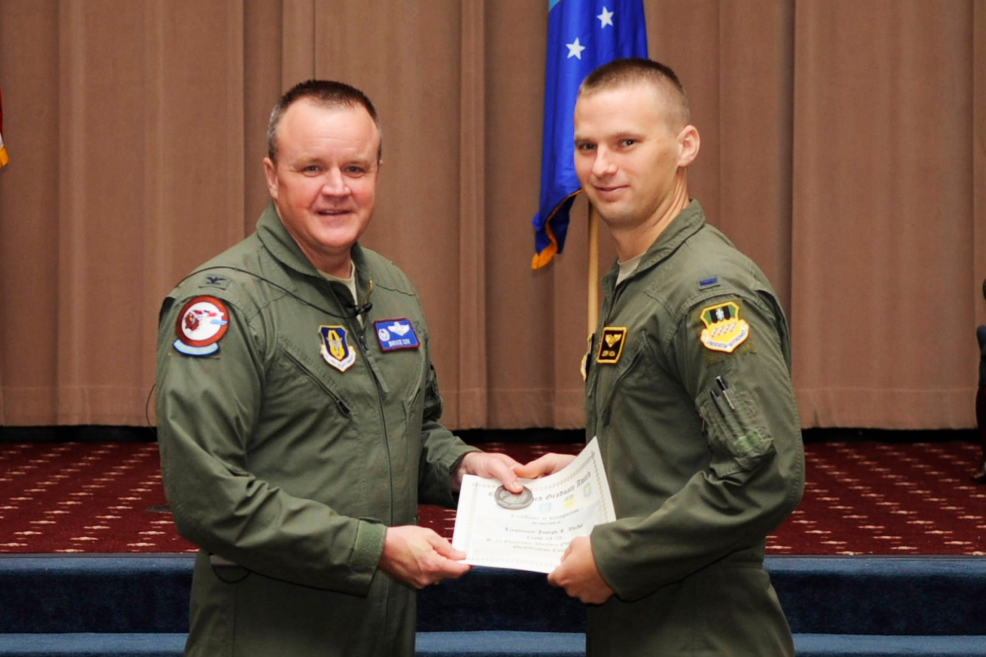 U.S. Air Force Reserve Col. Bruce Cox, 307th Bomb Wing commander, presents the Distinguished Graduate Award to 2nd Lt. Joseph Vacha during a Formal Training Unit (FTU) graduation ceremony, May 29, 2015, Barksdale Air Force Base, La. He also received the Electronic Warfare Officer Outstanding Academic Performer. Vacha graduated from the FTU as an Electronic Warfare Officer on the B-52H Stratofortress. (U.S. Air Force photo by Master Sgt. Laura Siebert /Released)