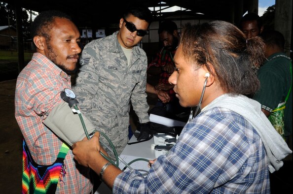 Staff Sgt. John Garcia, a 36th Medical Operations Squadron paramedic, from Andersen Air Force Base, Guam, works with a Papua New Guinea nursing student to check a patient’s vitals during Pacific Angel 15-4 inPapua New Guinea, May 31, 2015. PACANGEL is an annual joint humanitarian assistance mission that is designed to bring humanitarian civic assistance and combined civil-military operations to the Pacific region. (U.S. Air Force photo/Staff Sgt. Marcus Morris)