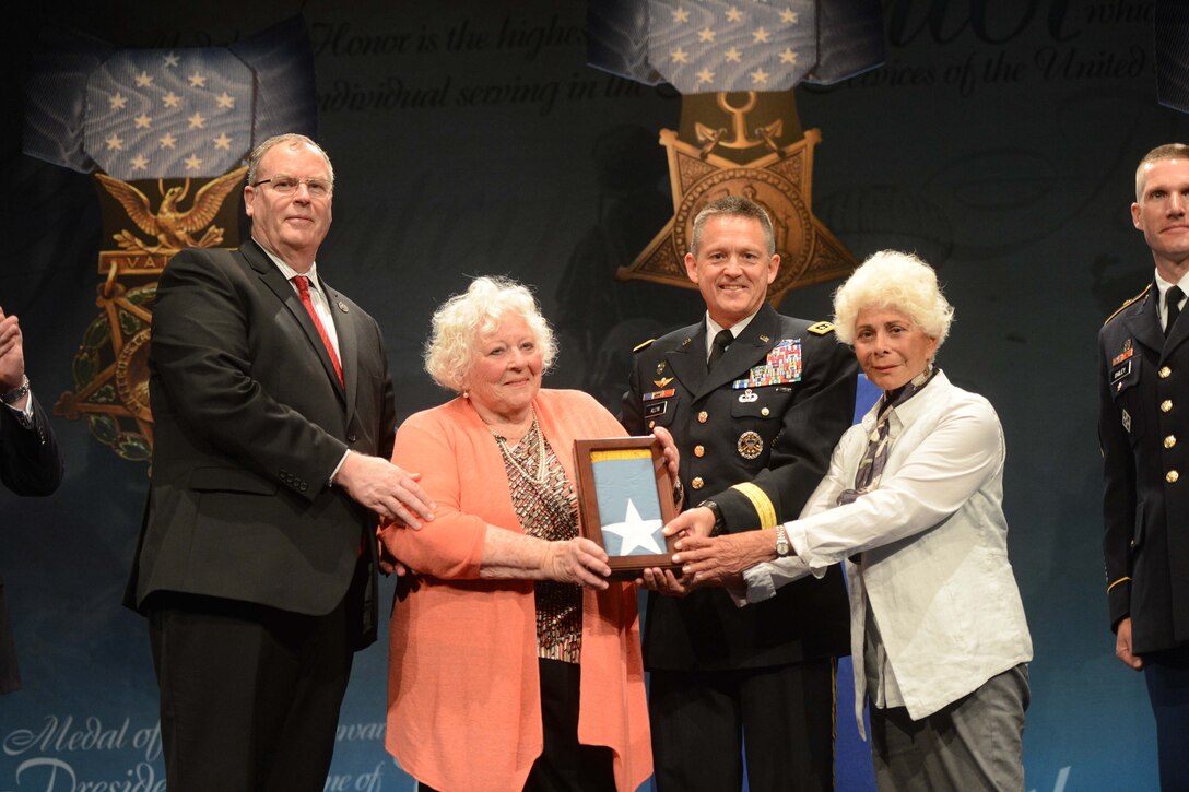 Deputy Defense Secretary Bob Work stands with Elsie Shemin-Roth, center, and Ina Shemin-Bass, the daughters of Medal of Honor recipient Army Sgt. William Shemin, after they accepted the Medal of Honor Flag on behalf of their late father during a ceremony at the Pentagon, June 3, 2015. During the event, Work inducted Shemin and Medal of Honor recipient Army Pvt. Henry Johnson into the Pentagon's Hall of Heroes. Shemin and Johnson were World War I veterans.