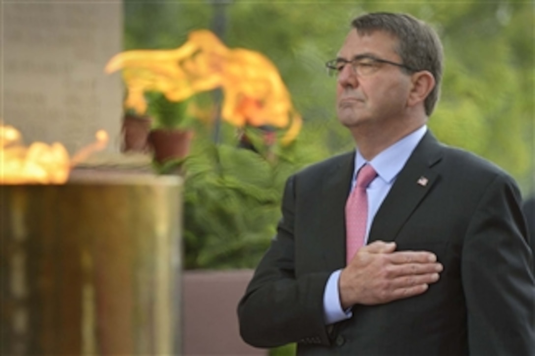 Placing his hand over his heart, U.S. Defense Secretary Ash Carter pauses for a moment of silence after laying a wreath at India Gate in New Delhi, June 3, 2015. 