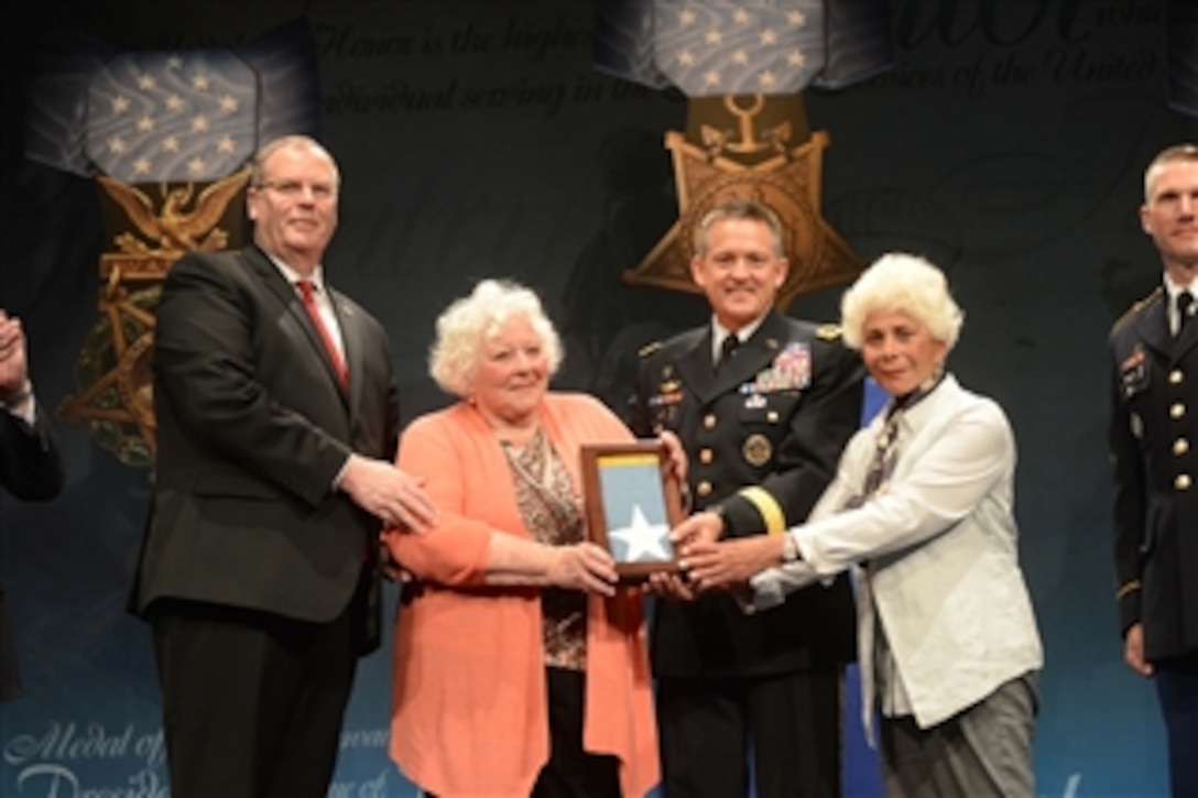 Deputy Defense Secretary Bob Work stands with Elsie Shemin-Roth, center, and Ina Shemin-Bass, the daughters of Medal of Honor recipient Army Sgt. William Shemin, after they accepted the Medal of Honor Flag on behalf of their late father during a ceremony at the Pentagon, June 3, 2015. During the event, Work inducted Shemin and Medal of Honor recipient Army Pvt. Henry Johnson into the Pentagon's Hall of Heroes. Shemin and Johnson were World War I veterans. 