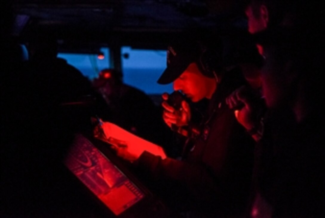 Navy Lt. j.g. P.G. Fabbri tracks the course of the aircraft carrier USS Harry S. Truman from the ship's bridge in the Atlantic Ocean, May 31, 2015.