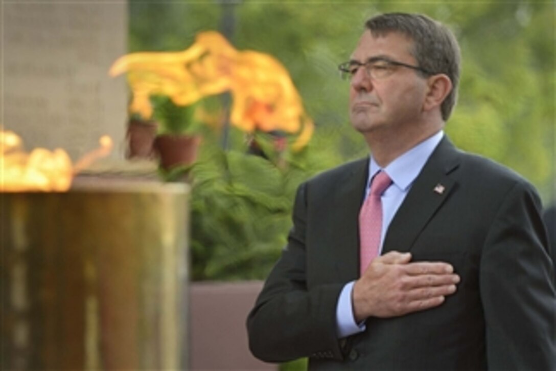 Placing his hand over his heart, U.S. Defense Secretary Ash Carter pauses for a moment of silence after laying a wreath at India Gate in New Delhi, June 3, 2015. 