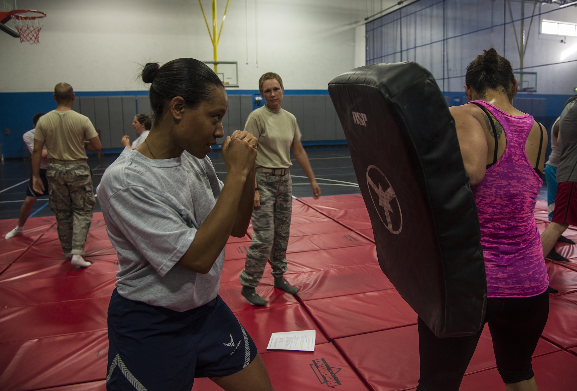 Master Sgt. Adrianne Smith, 379th Air Expeditionary Wing command post superintendent, positions herself to throw some jabs during a combatives class at the Blanchard-Preston Complex gym May 29, 2015 at Al Udeid Air Base, Qatar. Bi-weekly, Airmen of the 379th Expeditionary Security Forces Squadron instruct members on non-lethal ways to defend themselves. (U.S. Air Force photo byTech. Sgt. Rasheen Douglas)