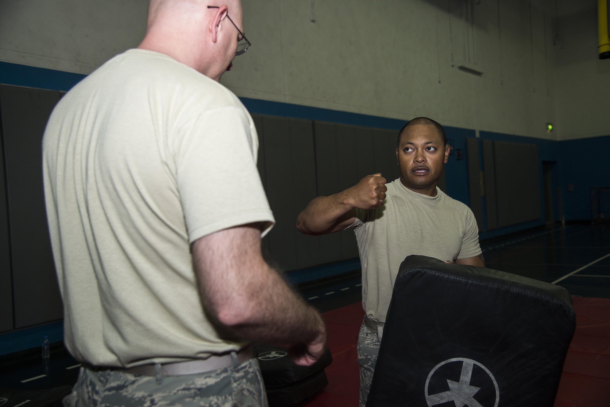 Tech Sgt. Chalom Pittman, Combined Air and Space Center force protection liasion officer and Check Six program manager, instructs on proper technique when throwing jabs and punches to Master Sgt. Rodney Hattery, 379th Expeditionary Operations Support Squadron weather flight lead, during a combatives class at the Blanchard-Preston Complex gym May 29, 2015 at Al Udeid Air Base, Qatar. Bi-weekly, Airmen of the 379th Expeditionary Security Forces Squadron instruct members on non-lethal ways to defend themselves. (U.S. Air Force photo by Tech. Sgt. Rasheen Douglas)