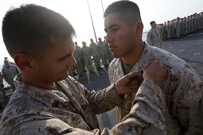 Sergeant Brandon Frazer, left, pins sergeant chevrons on Cpl. Jorge Echeveste, both riflemen with Kilo Company, Battalion Landing Team 3rd Battalion, 6th Marine Regiment, 24th Marine Expeditionary Unit, during a promotion ceremony aboard the amphibious dock landing ship USS Fort McHenry (LSD 43), April 1, 2015. The 24th MEU is embarked on the ships of the Iwo Jima Amphibious Ready Group and deployed to maintain regional security in the U.S. 5th Fleet area of operations.  (U.S. Marine Corps photo by Sgt. Devin Nichols)