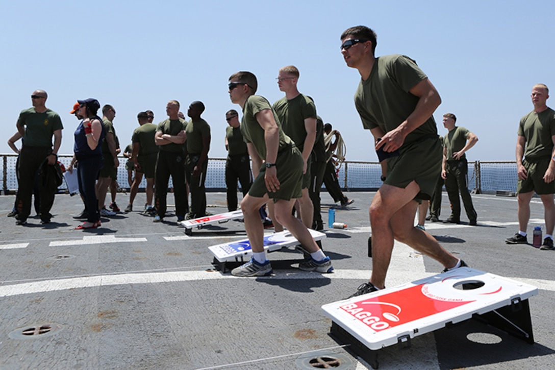 Marines with Kilo Company, Battalion Landing Team 3rd Battalion, 6th Marine Regiment, 24th Marine Expeditionary Unit, participate in a corn hole tournament during the “Halfway Block Party” aboard the amphibious dock landing ship USS Fort McHenry (LSD 43), April 2, 2015. The 24th MEU is embarked on the ships of the Iwo Jima Amphibious Ready Group and deployed to maintain regional security in the U.S. 5th Fleet area of operations.  (U.S. Marine Corps photo by Sgt. Devin Nichols)