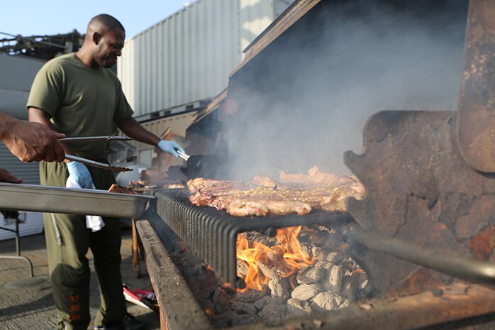 Staff Sgt. Quiam Woody, a food service specialist with Headquarters and Service Company, Battalion Landing Team 3rd Battalion, 6th Marine Regiment, 24th Marine Expeditionary Unit, cooks steaks on a grill during the “Halfway Block Party” aboard the amphibious dock landing ship USS Fort McHenry (LSD 43), April 2, 2015. The 24th MEU is embarked on the ships of the Iwo Jima Amphibious Ready Group and deployed to maintain regional security in the U.S. 5th Fleet area of operations.  (U.S. Marine Corps photo by Sgt. Devin Nichols)