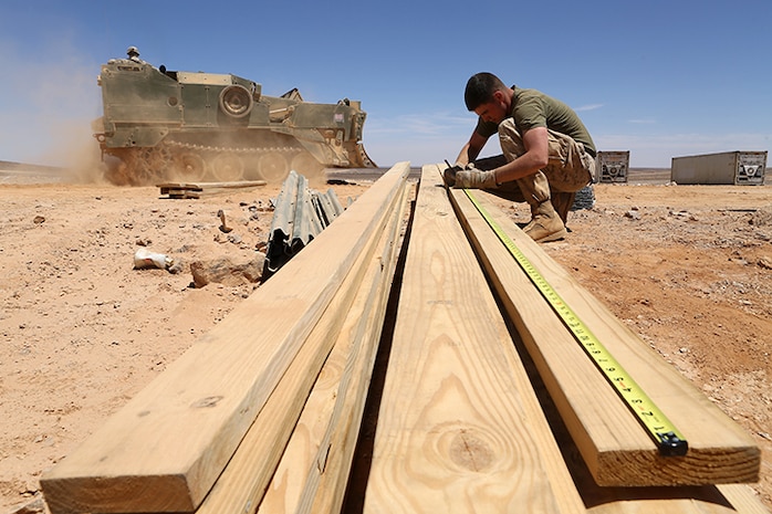 Cpl. Patrick Dempsey, a combat engineer with Kilo Company, Battalion Landing Team 3rd Battalion, 6th Marine Regiment, 24th Marine Expeditionary Unit, draws measurements on a piece of wood during Exercise Eager Lion 2015 at Wadi Al Shadiyah, Jordan, May 1, 2015. The 24th MEU is embarked on the ships of the Iwo Jima Amphibious Ready Group and deployed to maintain regional security in the U.S. 5th Fleet area of operations.  (U.S. Marine Corps photo by Sgt. Devin Nichols)