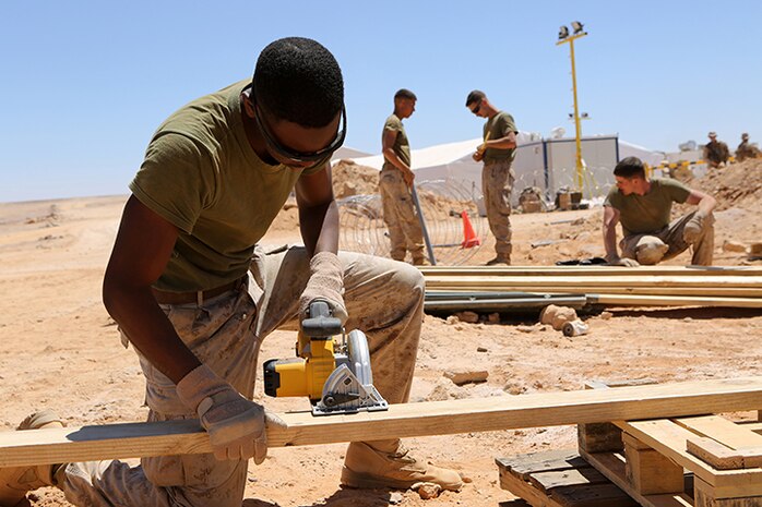 Lance Cpl. Jonathan Sumlin, a combat engineer with Kilo Company, Battalion Landing Team 3rd Battalion, 6th Marine Regiment, 24th Marine Expeditionary Unit, cuts wood pieces during Exercise Eager Lion 2015 at Wadi Al Shadiyah, Jordan, May 1, 2015. The 24th MEU is embarked on the ships of the Iwo Jima Amphibious Ready Group and deployed to maintain regional security in the U.S. 5th Fleet area of operations.  (U.S. Marine Corps photo by Sgt. Devin Nichols)