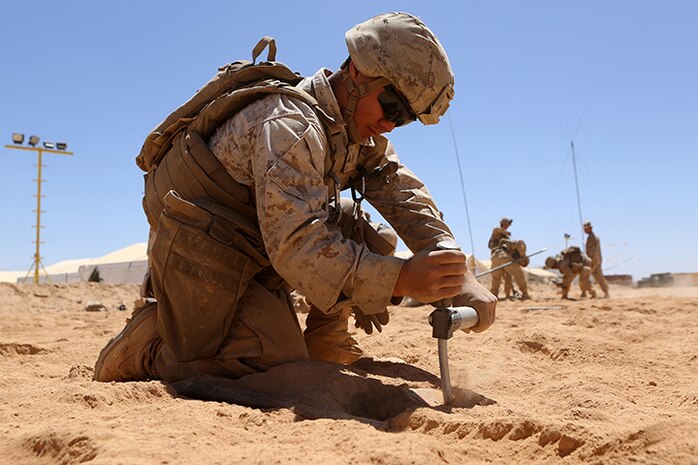 Lance Cpl. Chorly C. Xiong, a field radio operator with Headquarters and Service Company, Battalion Landing Team 3rd Battalion, 6th Marine Regiment, 24th Marine Expeditionary Unit, hammers the base plate of an OE-254 VHF low band antenna into the ground in preparation for Exercise Eager Lion 2015 in Jordan, May 3, 2015. Eager Lion is a recurring multinational exercise designed to strengthen military-to-military relationships, increase interoperability between partner nations, and enhance regional security and stability. The 24th MEU is embarked on the ships of the Iwo Jima Amphibious Ready Group and deployed to maintain regional security in the U.S. 5th Fleet area of operations. (U.S. Marine Corps photo by Sgt. Devin Nichols/Released)