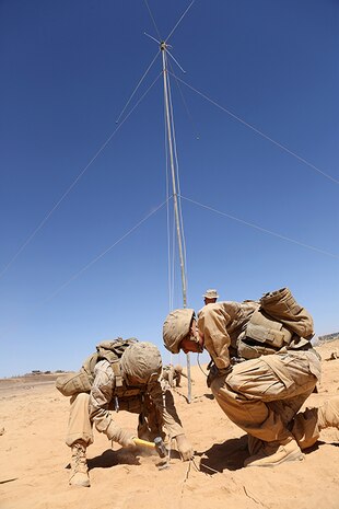 Lance Cpls. William S. Quinn, left, and Patrick J. Bennet, both field radio operators with Headquarters and Service Company, Battalion Landing Team 3rd Battalion, 6th Marine Regiment, 24th Marine Expeditionary Unit, tie down an OE-254 VHF low band antenna in preparation for Exercise Eager Lion 2015 in Jordan, May 3, 2015. Eager Lion is a recurring multinational exercise designed to strengthen military-to-military relationships, increase interoperability between partner nations, and enhance regional security and stability. The 24th MEU is embarked on the ships of the Iwo Jima Amphibious Ready Group and deployed to maintain regional security in the U.S. 5th Fleet area of operations. (U.S. Marine Corps photo by Sgt. Devin Nichols/Released) 