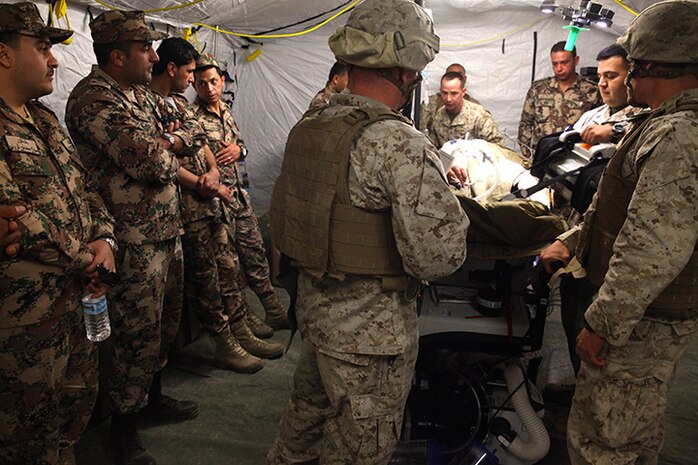 Jordan military personnel, left, with Jordanian Role 2 Medical Team, observe as a simulated casualty is operated on during casualty evacuation training in Wadi Al Shadiyah, Jordan, May 3, 2015. The 24th MEU is embarked on the ships of the Iwo Jima Amphibious Ready Group and deployed to maintain regional security in the U.S. 5th Fleet  area of operations. (U.S. Marine Corps photo by Lance Cpl. Austin A. Lewis)