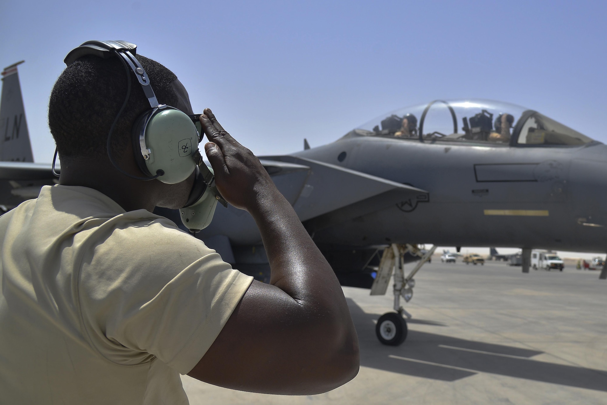 Staff Sgt. Oren renders a salute to F-15E Strike Eagle aircrew members as they taxi to the runway at an undisclosed location in Southwest Asia May 31, 2015. Sgt. Oren is a dedicated crew chief assigned to the 380th Expeditionary Aircraft Maintenance Squadron. (U.S. Air Force photo/Tech. Sgt. Christopher Boitz) 