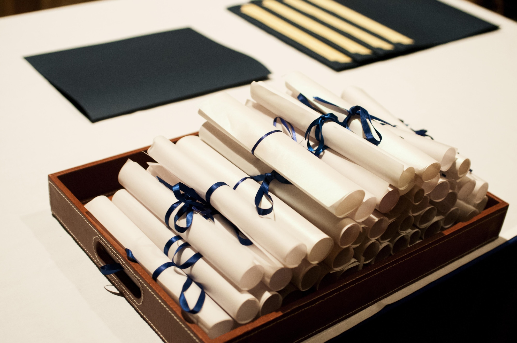 Diploma certificates sit on a table during the Community College of the Air Force graduation ceremony at the base theater on Goodfellow Air Force Base, Texas, May 8, 2015. The ceremony also included the Pitsenbarger awards and Powell Warrior award. (U.S. Air Force photo by Senior Airman Scott Jackson)