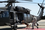 Senior Airman Justin Ricketts, 66th Security Forces Squadron military working dog handler, and MWD Frenky load a Massachusetts Army National Guard Black Hawk during Helicopter Emerging Training on the Hanscom flightline May 27, 2015. The first-of-its-kind training for the 66 SFS handlers simulated a combat environment for their canines to practice entering and exiting a helicopter. 