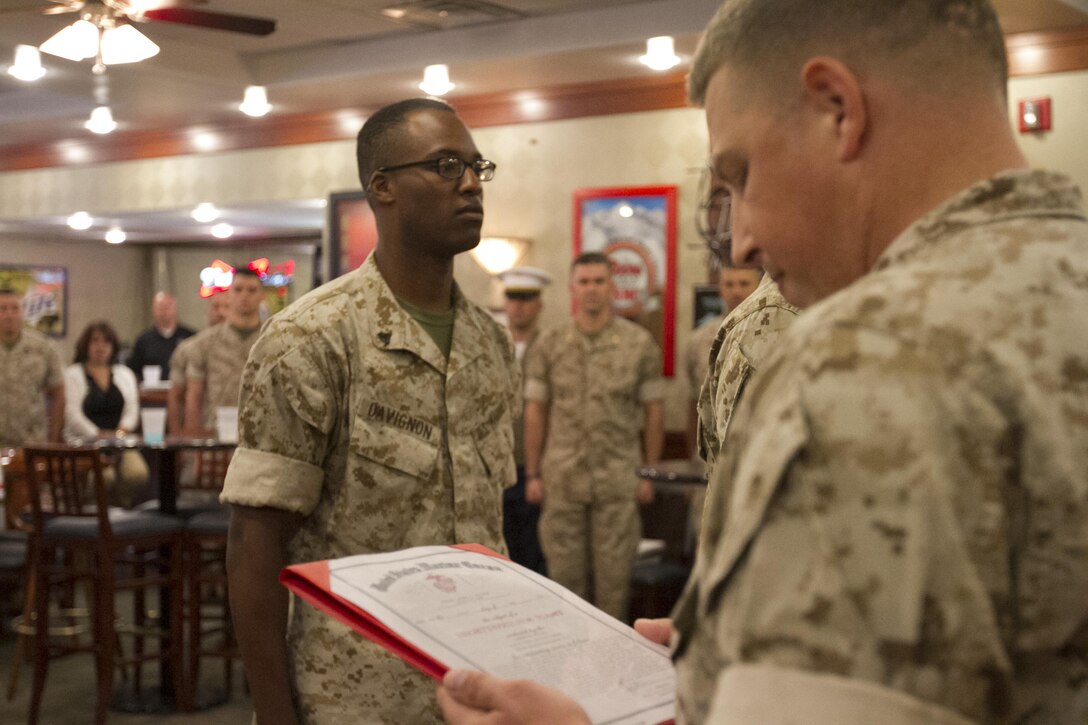Master Sgt. Jason Bruce reads an end of tour award for Cpl. Jeremy Davignon during a Marine Corps Institute Company function at the Staff Non-Commissioned Officer club, Marine Barracks Washington, D.C., June 3, 2015.(U.S. Marine Corps photo by Cpl. Skye Davis/Released)

