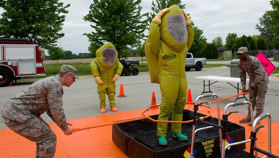 Airman 1st Class Joshua Knisley, 375th Civil Engineer Squadron emergency management specialist from Scott Air Force Base, Ill., and Senior Airman Brandon Stone, 509th Civil Engineer Squadron EM specialist from Whiteman Air Force Base, Mo., simulate the removal of hazardous material from Staff Sgt. Mitchell Birdsong, 60th Civil Engineer Squadron EM specialist from Travis Air Force Base, Calif., during an exercise at Grissom Air Reserve Base, Ind., May 19, 2015. The exercise was part of a 10-day course that allowed EM specialists from five major commands to unite and hone EM principals while incorporating combat skills and obtaining mandated recertifications. (U.S. Air Force photo/Tech. Sgt. Benjamin Mota)