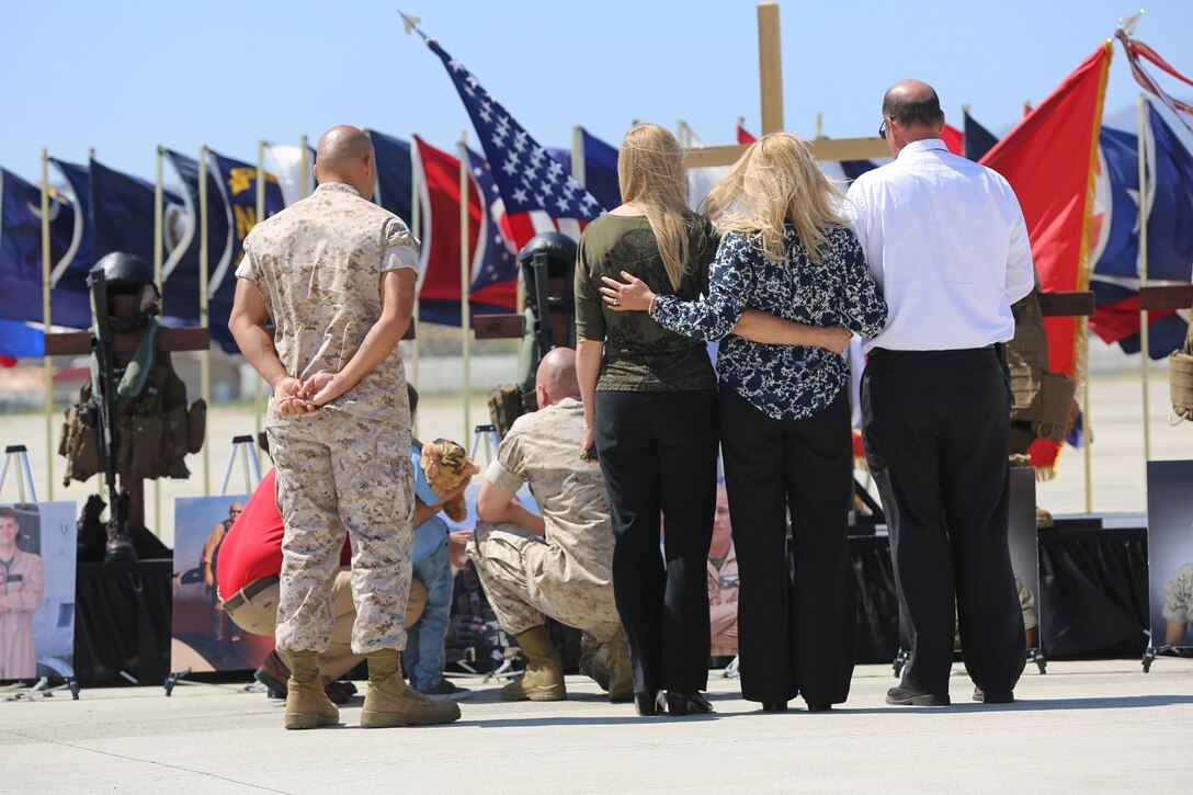 Family and friends gather in front of a display dedicated to fallen Marines at a memorial service aboard Marine Corps Air Station Camp Pendleton, California, June 3. The ceremony honored six Marines killed in a UH-1Y helicopter crash while conducting relief efforts in Nepal.