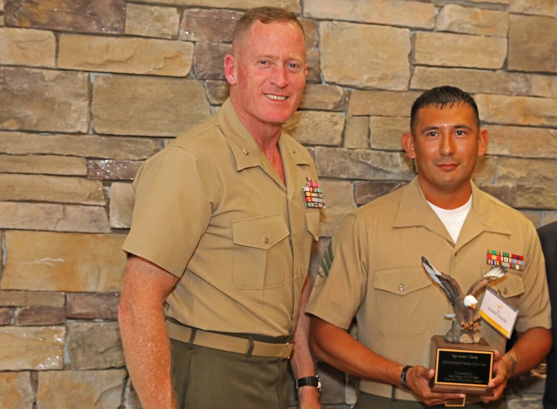 Brig. Gen. Edward D. Banta, Commanding General, Marine Corps Base Camp Pendleton, Marine Corps Installations - West, presents the Marine Enlisted Father of the Year Award to Sgt. Jerald I. Davila, 1st Transportation Battalion, 1st Marine Logistics Group, during a ceremony hosted by the San Diego Council, United States Navy League, at the Pacific Views Events Center here, June 3.