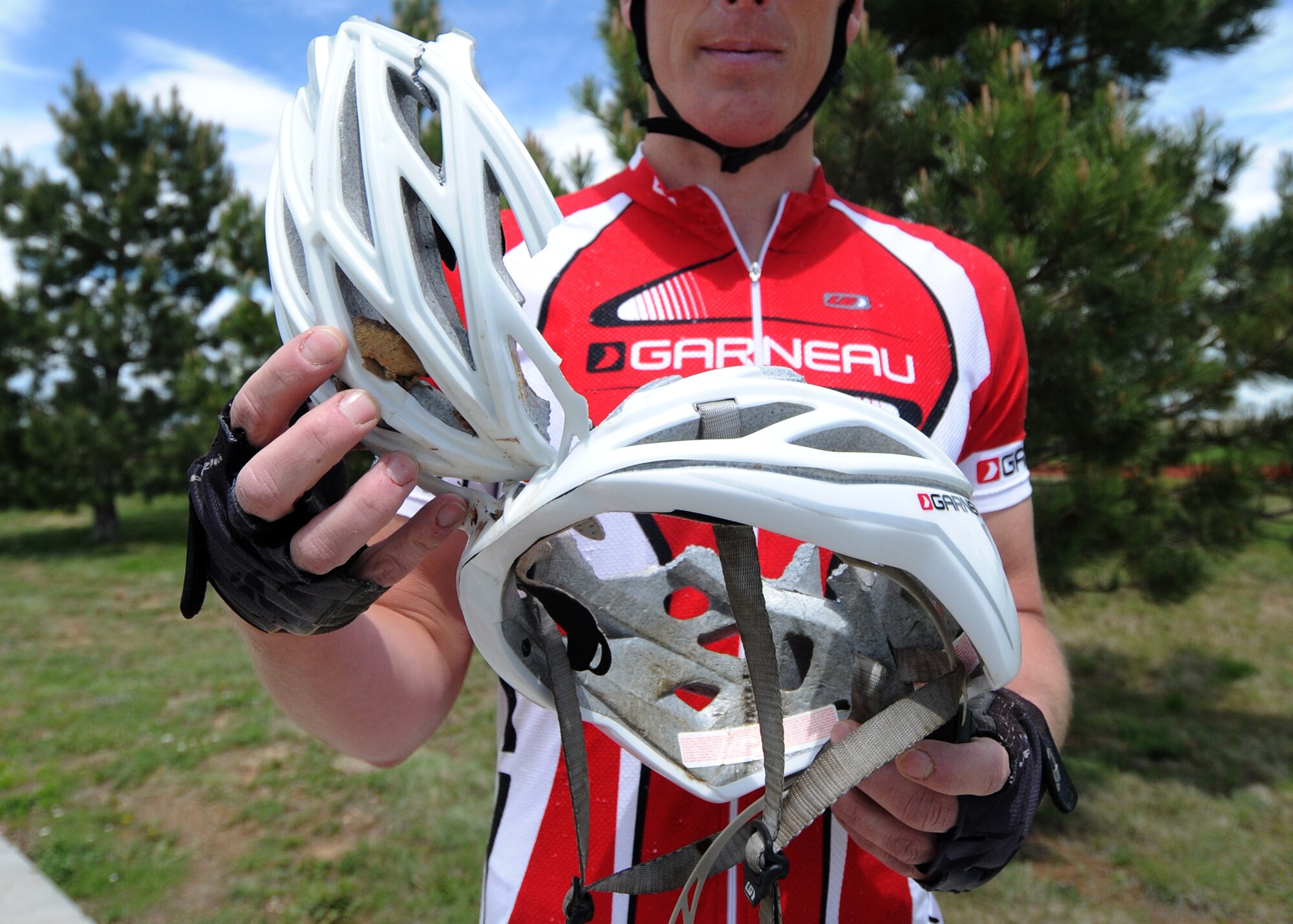 Before a bike ride May 28, 2015, Derek Hamby, the 50th Space Wing Manpower and Organization chief at Schriever Air Force Base, Colo., shows off the helmet he was wearing during a serious bicycle accident in November 2014. Although his injuries were severe, Hamby’s helmet saved his life. (U.S. Air Force photo/Staff Sgt. Debbie Lockhart)