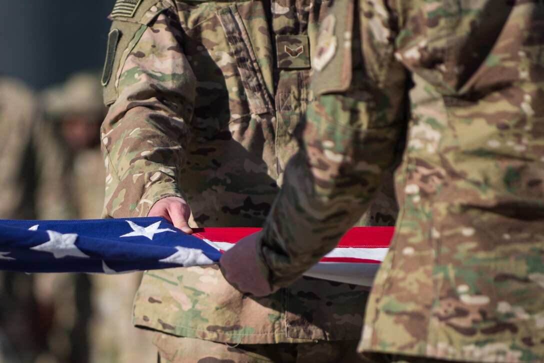 U.S. Airmen with the Bagram Air Field (BAF) honor guard fold the U.S. flag during a remembrance ceremony and retreat in Afghanistan, May 26, 2015. Service members at BAF gathered during the ceremony to remember those who gave their lives while deployed to Afghanistan. (U.S. Air Force photo by Tech. Sgt. Joseph Swafford/Released)