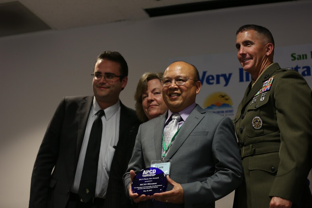 Col. John Farnam, right, commanding officer of Marine Corps Air Station Miramar, and Luis Eria, center, a MCAS Miramar environmental engineer and air quality program manager accept the Clean Air Award from the San Diego County Air Pollution Control District in San Diego, May 28. Miramar reduced electrical energy and water use, and increased energy from renewable resources.