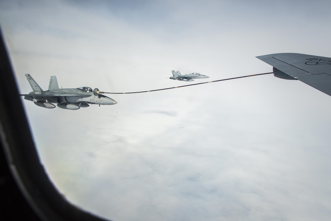 Royal Canadian Air Force CF-18 Hornets fly alongside a 22nd Air Refueling Wing KC-135 Stratotanker as the CF-18s each take turns refueling from a multi-point refueling system pod during exercise Amalgam Dart 15-2 May 29, 2015, over the Arctic Ocean. These pod modifications enhance the efficiency and flexibility of the Air Force's aerial refueling fleet, enabling KC-135s to refuel NATO and U.S. Navy aircraft. The KC-135 was from McConnell Air Force Base, Kan., and operated by a 92nd Air Refueling Wing crew from Fairchild AFB, Wash. (U.S. Air Force photo/Staff Sgt. Benjamin W. Stratton)