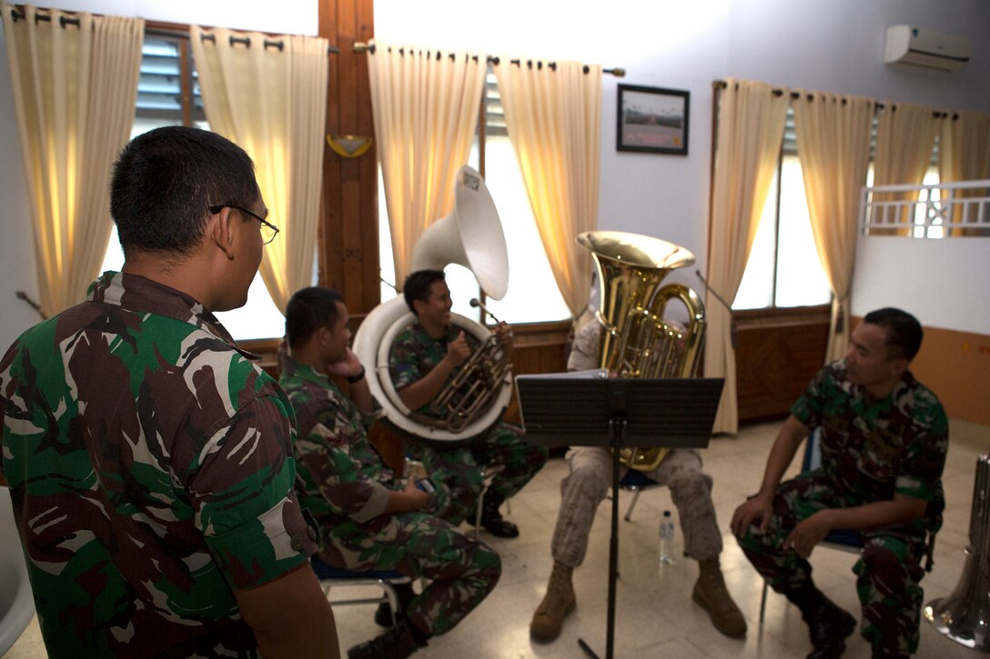 The Indonesian Korps Marinir band officer watches KORMAR band members and U.S. Marine Cpl. Steven Mowen, a U.S. Marine Corps Forces, Pacific Band tuba player, practice together, June 3, 2015. The musicians from both countries' bands practiced together and shared their knowledge on music throughout the day, culminating in a concert for Indonesian KORMAR aboard the base. This is the first time the two bands have played together.