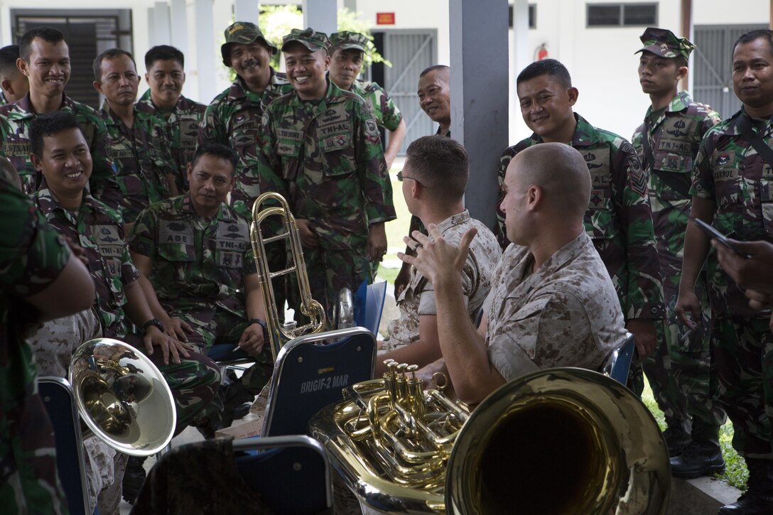 U.S. Marine Cpl. Steven Mowen, a tuba player and U.S. Marine Cpl. Mitchem Anderson, a trombone player with the U.S. Marine Corps Forces, Pacific Band, converse with Indonesian Korps Marinir on the 2nd Marine Force, Jakarta Marine Base, June 3, 2015. The musicians from both countries' bands practiced together and shared their knowledge on music throughout the day, culminating in a concert for Indonesian KORMAR aboard the base. This is the first time the two bands have played together. 