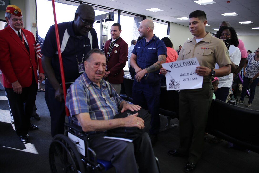Pvt. Marvin A. Rolansky, a World War II Marine veteran, Prisoner of War and Medal of Honor recipient, is greeted by service members, veterans and airline travelers at Louis Armstrong International Airport in Kenner, La., June 3, 2015. Rolansky was captured by the Japanese after the fall of Guam on Dec. 9, 1941, and spent four years in a labor camp until his return to U.S. military control in 1945 after the end of the war. Rolansky is one of a group of WWII POWs who visited New Orleans for the American Defenders of Bataan and Corregidor Memorial Society Reunion June 2-6, 2015. 