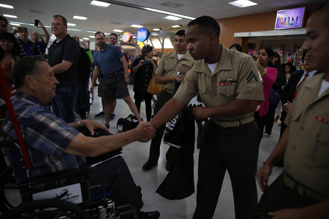 Pvt. Marvin A. Rolansky, a World War II Marine veteran and Prisoner of War Medal of Honor recipient, is greeted by Cpl. Jordan L. Bradford, a recruiting and retention clerk with Marine Forces Reserve, at Louis Armstrong International Airport in Kenner, La., June 3, 2015. Rolansky was captured by the Japanese after the fall of Guam on Dec. 9, 1941, and spent four years in a labor camp until his return to U.S. military control in 1945 after the end of the war. Rolansky is one of a group of WWII POWs who visited New Orleans for the American Defenders of Bataan and Corregidor Memorial Society Reunion June 2-6, 2015. 