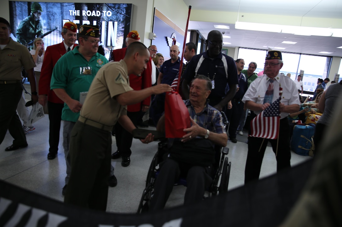 Pvt. Marvin A. Rolansky, a World War II Marine veteran and Prisoner of War Medal of Honor recipient, is greeted by service members, veterans and airline travelers at Louis Armstrong International Airport in Kenner, La., June 3, 2015. Rolansky was captured by the Japanese after the fall of Guam on Dec. 9, 1941, and spent four years in a labor camp until his return to U.S. military control in 1945 after the end of the war. Rolansky is one of a group of WWII POWs who visited New Orleans for the American Defenders of Bataan and Corregidor Memorial Society Reunion June 2-6, 2015. 