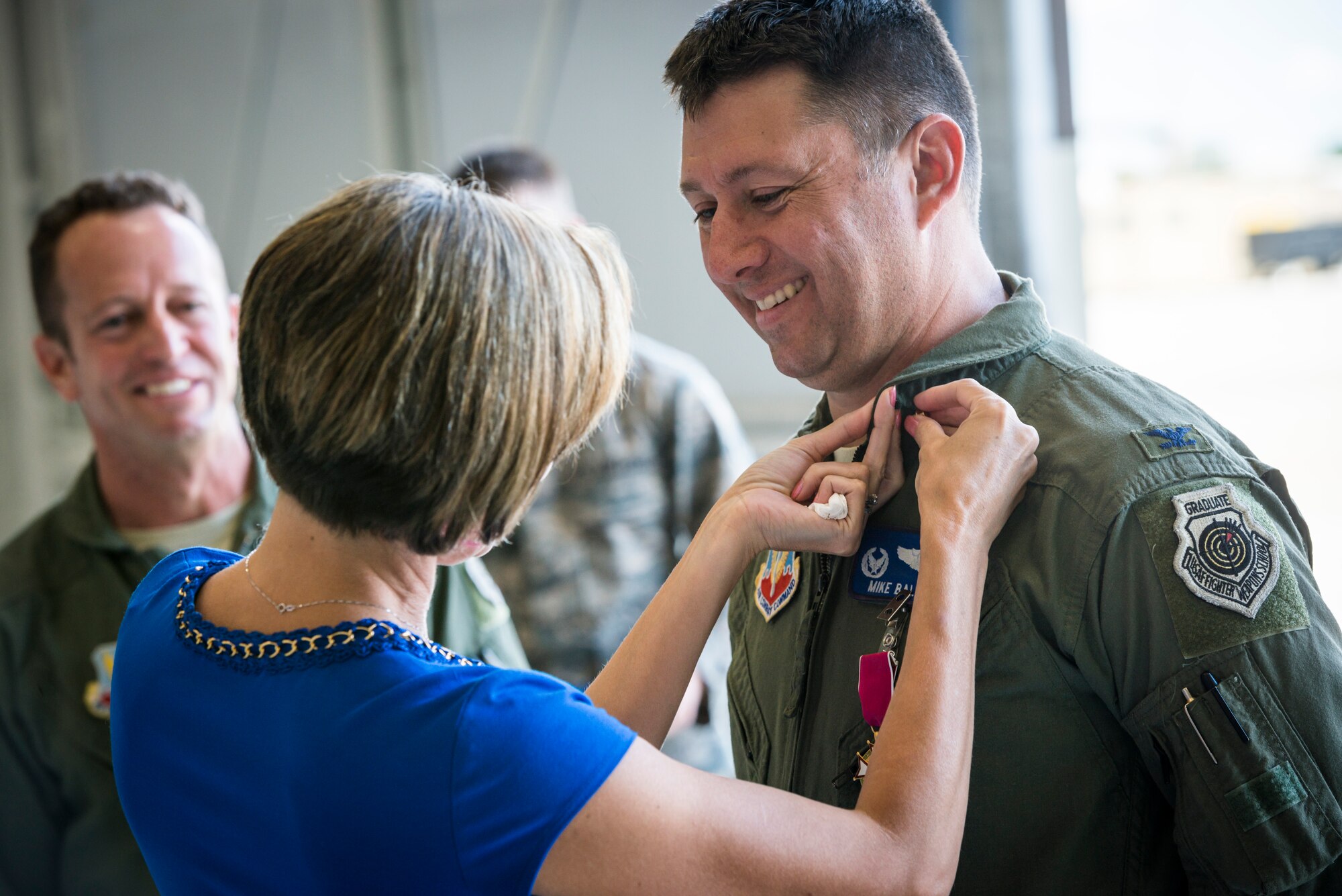 Veronica Ballek, wife of Col. Michael Ballek, pins a retirement pin on her husband during his retirement ceremony at Mountain Home Air Force Base, Idaho, June 2, 2015. Colonel Ballek said goodbye to the Gunfighters, but promised to return from time to time. (U.S. Air Force photo/Tech. Sgt. Samuel Morse)