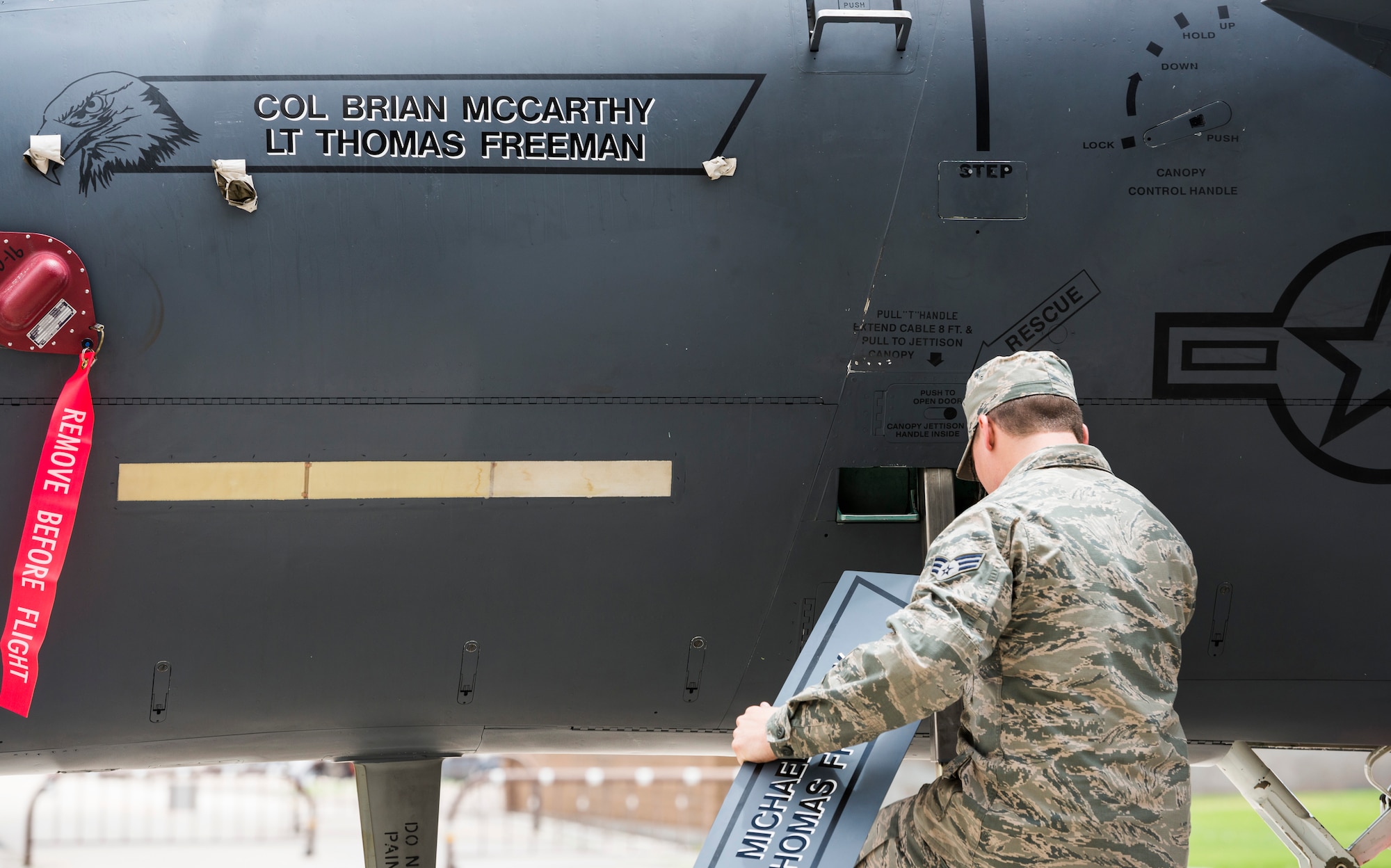 Senior Airman Joseph Bower, 366th Aircraft Maintenance Squadron crewchief, reveals Col. Brian McCarthy's name on the 366th Operations Group flagship F-15E Strike Eagle during the Group's change of command ceremony at Mountain Home Air Force Base, Idaho, June 2, 2015. This is a traditional gesture welcoming McCarthy as the new 366th OG commander. (U.S. Air Force photo/Tech. Sgt. Samuel Morse)