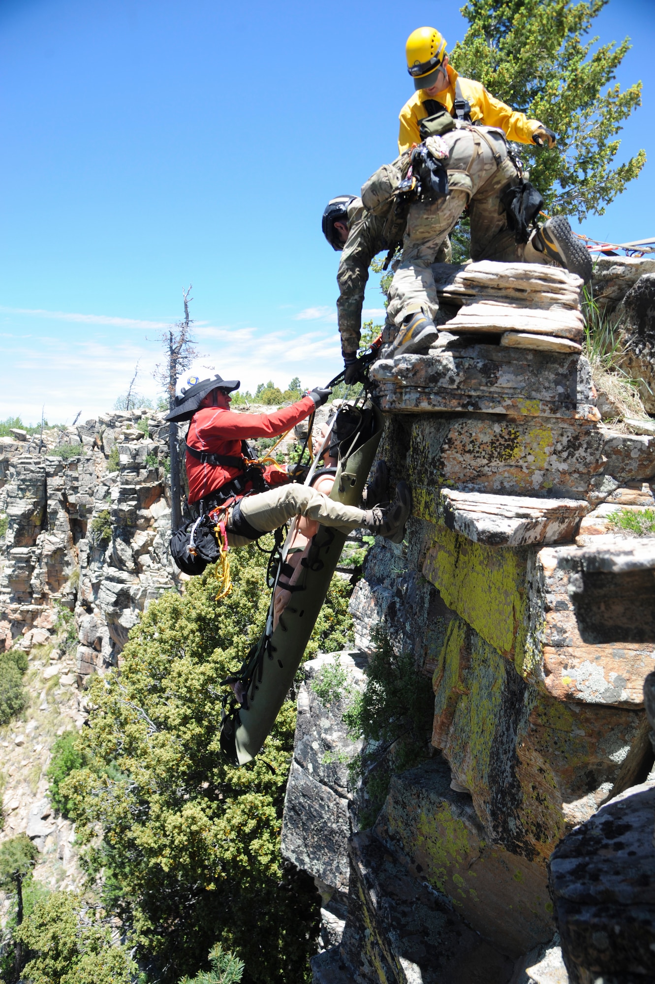 Members of several interagency search and rescue teams and a 306th Rescue Squadron reserve pararescueman provide instruction while pulling a simulated patient and rescue member to the top of cliffside during Angel Thunder 2015 high angle rescue training at Mongollon Rim, Ariz., June 3, 2015. Angel Thunder is the world’s largest personnel recovery exercise, hosting 11 partner nations and nine interagencies at Davis-Monthan Air Force Base, Ariz. (U.S. Air Force photo by Senior Airman Betty R. Chevalier/Released)