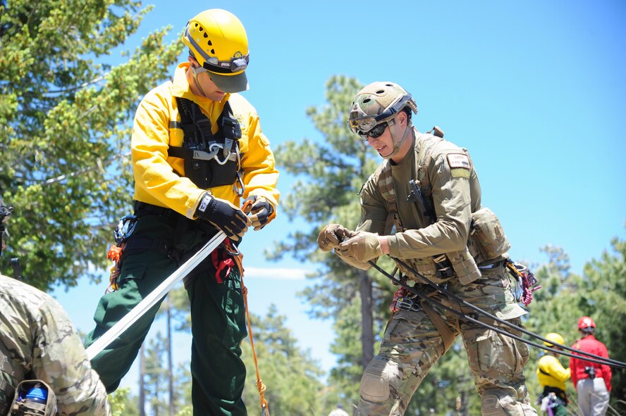 John Vonk, Grand Canyon National Park Service search and rescue team member, and U.S. Air Force Staff Sgt. Matthew Gaddy, 306th Rescue Squadron reserve pararescueman, connect ropes to pull a simulated patient to the top of a steep cliffside during Angel Thunder 2015 high angle rescue training at Mongollon Rim, Ariz., June 3, 2015. Angel Thunder is hosted by the 355th Fighter Wing at Davis-Monthan Air Force Base, Ariz., but many flying operation will extend throughout Arizona, New Mexico and California. (U.S. Air Force photo by Senior Airman Betty R. Chevalier/Released)