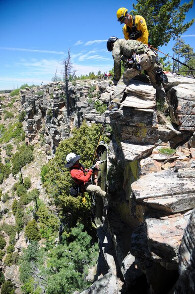 Members of several interagency search and rescue teams and a 306th Rescue Squadron reserve pararescueman provide instruction while pulling a simulated patient and rescue member to the top of cliffside during Angel Thunder 2015 high angle rescue training at Mongollon Rim, Ariz., June 3, 2015. The objective of the exercise is to train personnel recovery forces to prepare, plan, execute and adapt for a rescue mission. (U.S. Air Force photo by Senior Airman Betty R. Chevalier/Released)