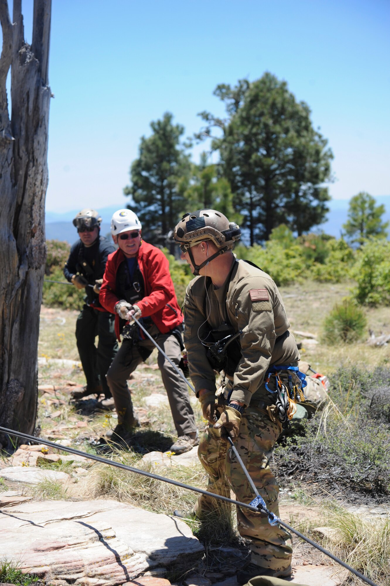 A 306th Rescue Squadron reserve pararescueman and members of several interagency search and rescue teams use combined strength to hoist a simulated patient up a steep cliffside during Angel Thunder 2015 high angle rescue training at Mongollon Rim, Ariz., June 3, 2015. Angel Thunder is hosted by the 355th Fighter Wing at Davis-Monthan Air Force Base, Ariz., but many flying operation will extend throughout Arizona, New Mexico and California. (U.S. Air Force photo by Senior Airman Betty R. Chevalier/Released)