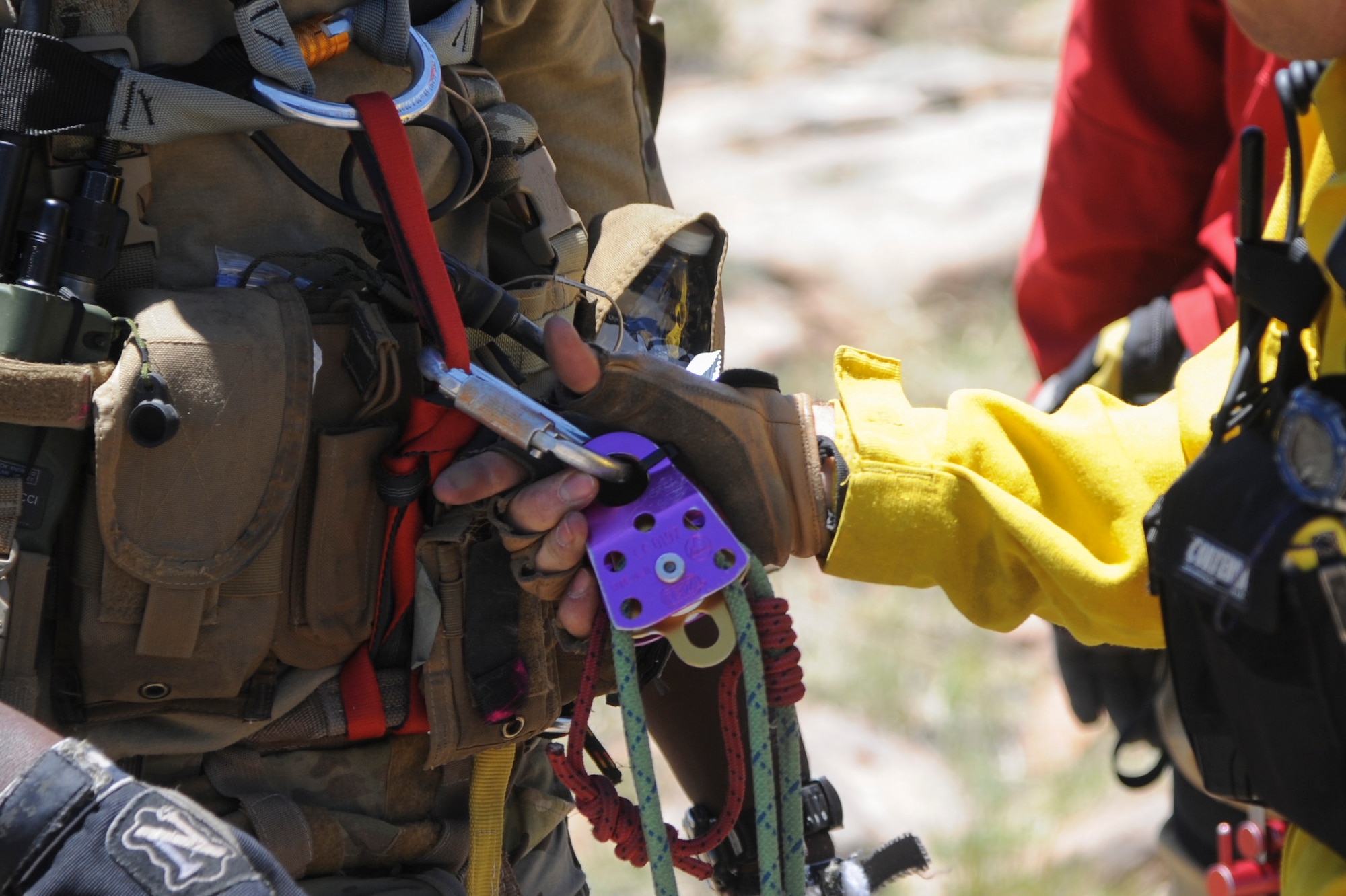 A member of the Grand Canyon National Park Service search and rescue team secures rope, carabiners and pulley climbing equipment to a 306th Rescue Squadron reserve pararescueman before he descends over a cliffside to simulate rescuing a patient during Angel Thunder 2015 high angle rescue training at Mongollon Rim, Ariz., June 3, 2015. Angel Thunder is the largest personnel recovery exercise in the world combining joint, coalition and interagency personnel. Participants will train through the full spectrum of personnel recovery capabilities with numerous types of aircraft. (U.S. Air Force photo by Senior Airman Betty R. Chevalier/Released)