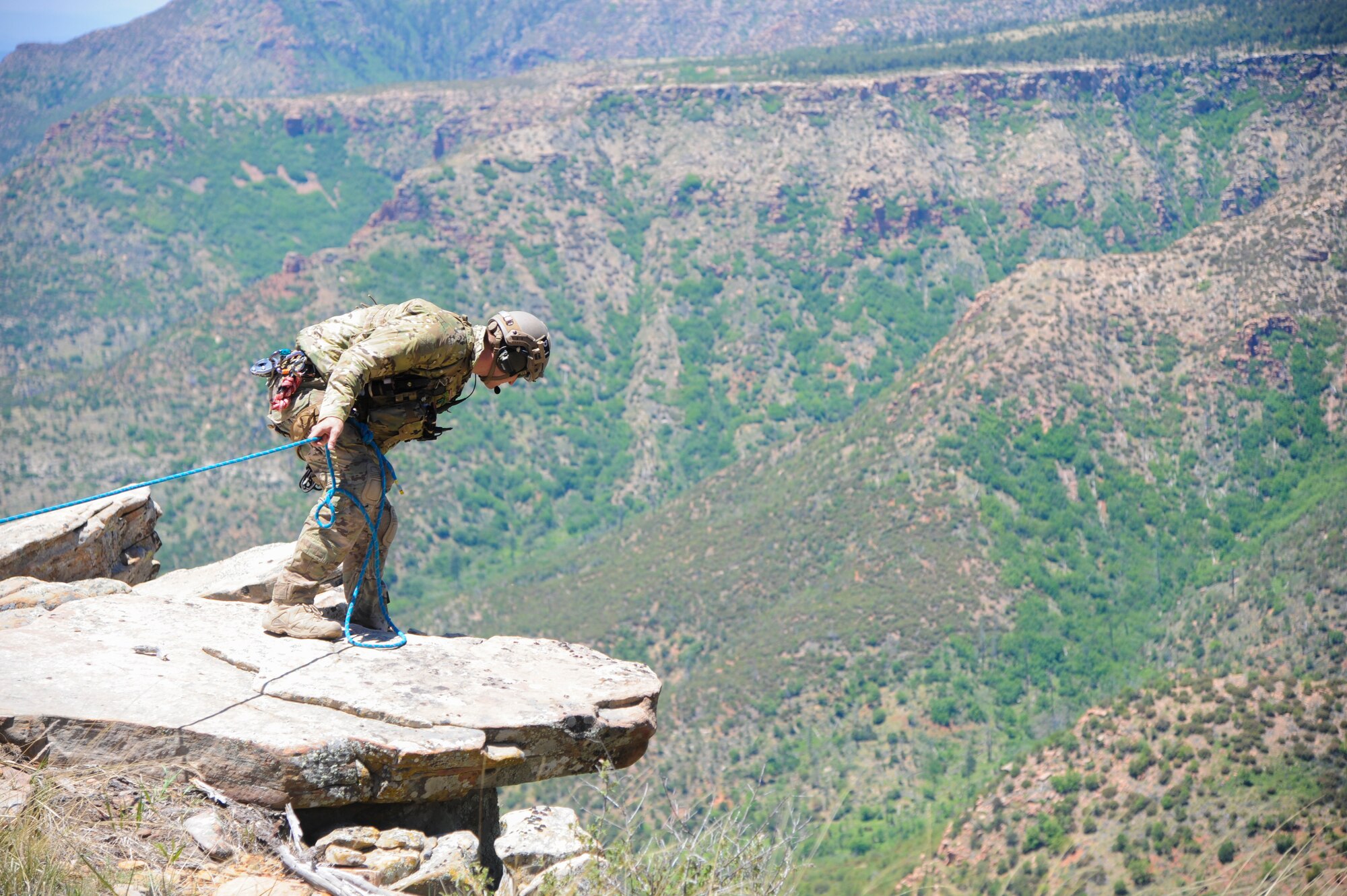 A 306th Rescue Squadron reserve pararescueman communicates with a search and rescue team member who is recovering a simulated patient during Angel Thunder 2015 high angle rescue training at Mongollon Rim, Ariz., June 3, 2015. Angel Thunder is the world’s largest personnel recovery exercise, hosting 11 partner nations and nine interagencies at Davis-Monthan Air Force Base, Ariz. (U.S. Air Force photo by Senior Airman Betty R. Chevalier/Released)