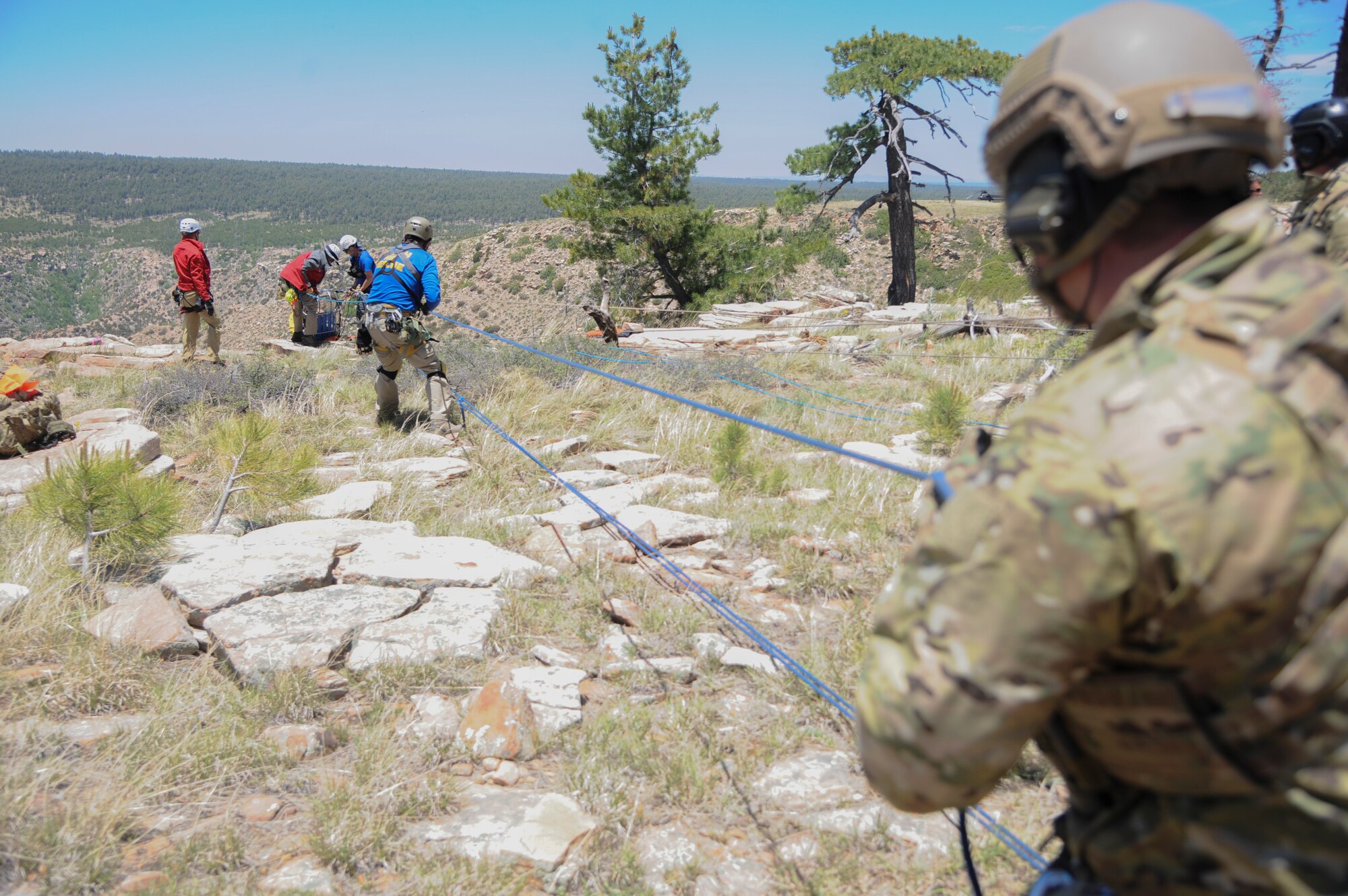 A 306th Rescue Squadron reserve pararescueman and members of several interagency search and rescue teams use combined strength to hoist a simulated patient up a steep cliffside during Angel Thunder 2015 high angle rescue training at Mongollon Rim, Ariz., June 3, 2015. Angel Thunder is hosted by the 355th Fighter Wing at Davis-Monthan Air Force Base, Ariz., but many flying operation will extend throughout Arizona, New Mexico and California. (U.S. Air Force photo by Senior Airman Betty R. Chevalier/Released)