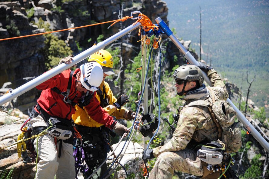 Members of several interagency search and rescue teams and a 306th Rescue Squadron reserve pararescueman connect ropes to an Arizona Vortex Tripod during Angel Thunder 2015 high angle rescue training at Mongollon Rim, Ariz., June 3, 2015. The objective of the exercise is to train personnel recovery forces to prepare, plan, execute and adapt for a rescue mission. (U.S. Air Force photo by Senior Airman Betty R. Chevalier/Released)