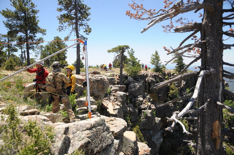 Members of several interagency search and rescue teams and a 306th Rescue Squadron reserve pararescueman connect ropes to an Arizona Vortex Tripod during Angel Thunder 2015 high angle rescue training at Mongollon Rim, Ariz., June 3, 2015. Angel Thunder is the world’s largest personnel recovery exercise, hosting 11 partner nations and nine interagencies at Davis-Monthan Air Force Base, Ariz. (U.S. Air Force photo by Senior Airman Betty R. Chevalier/Released)